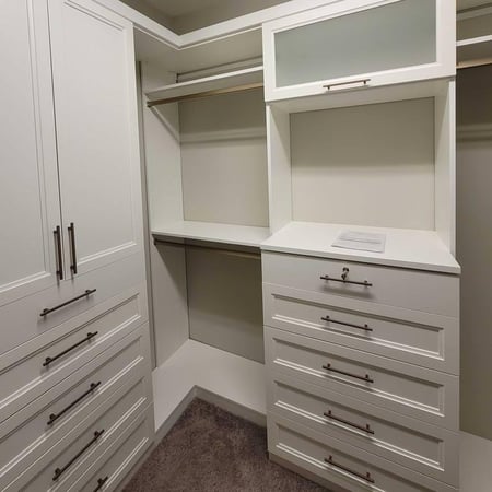 A white walk-in closet designed for organized storage.