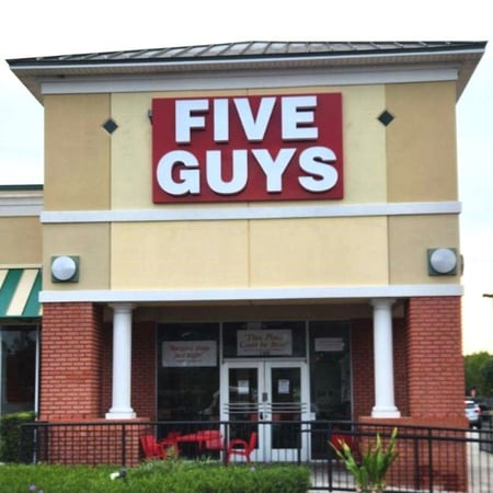 Exterior photograph of the entrance to the Five Guys restaurant at 6126 Semoran Boulevard in Orlando, Florida.