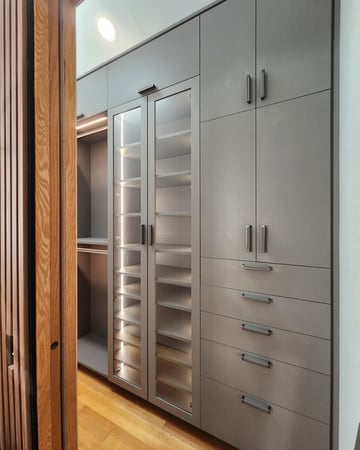 grey wardrobe wall unit with glass doors and lighting