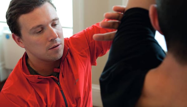 Physiotherapist showing patient shoulder exercises