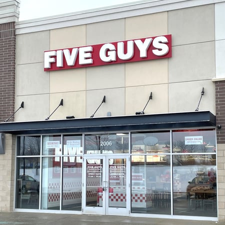 Exterior photograph of the entrance to the Five Guys restaurant at 2006 East Beltline Ave. NE in Grand Rapids, Michigan.