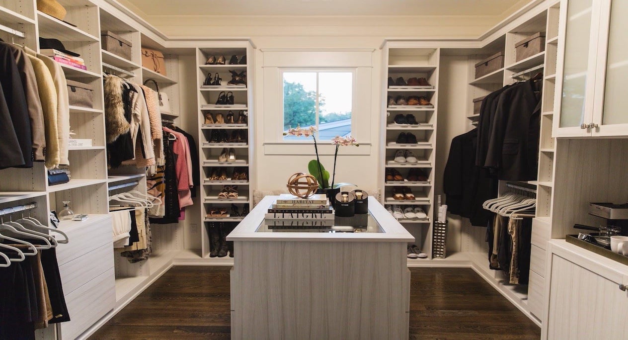 walk in closet with shoe shelves, hanging space, and an island
