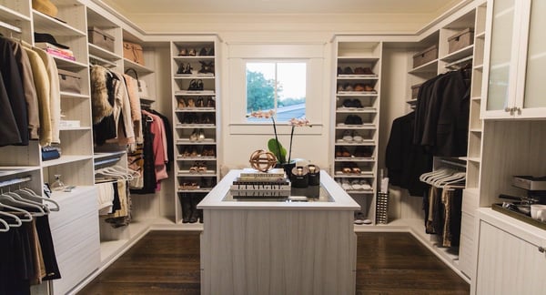 walk in closet with shoe shelves, hanging space, and an island