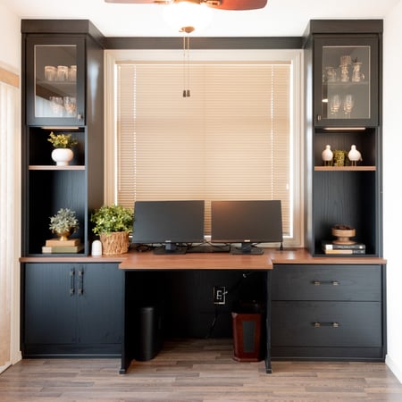 Dark and moody home office with contrasting shelving and countertop.