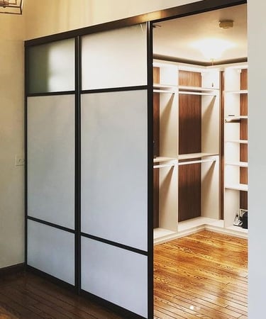white and glass sliding doors with brown and white closet behind