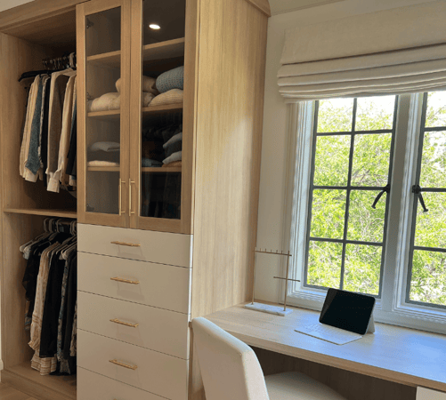 Img 1 - California Closets Westchester NY White and Natural Wood Custom Closet and Workspace area with Drawers, Double Hanging to maximize storage, Clear Glass Doors with Shelving and a Desk for workspace
