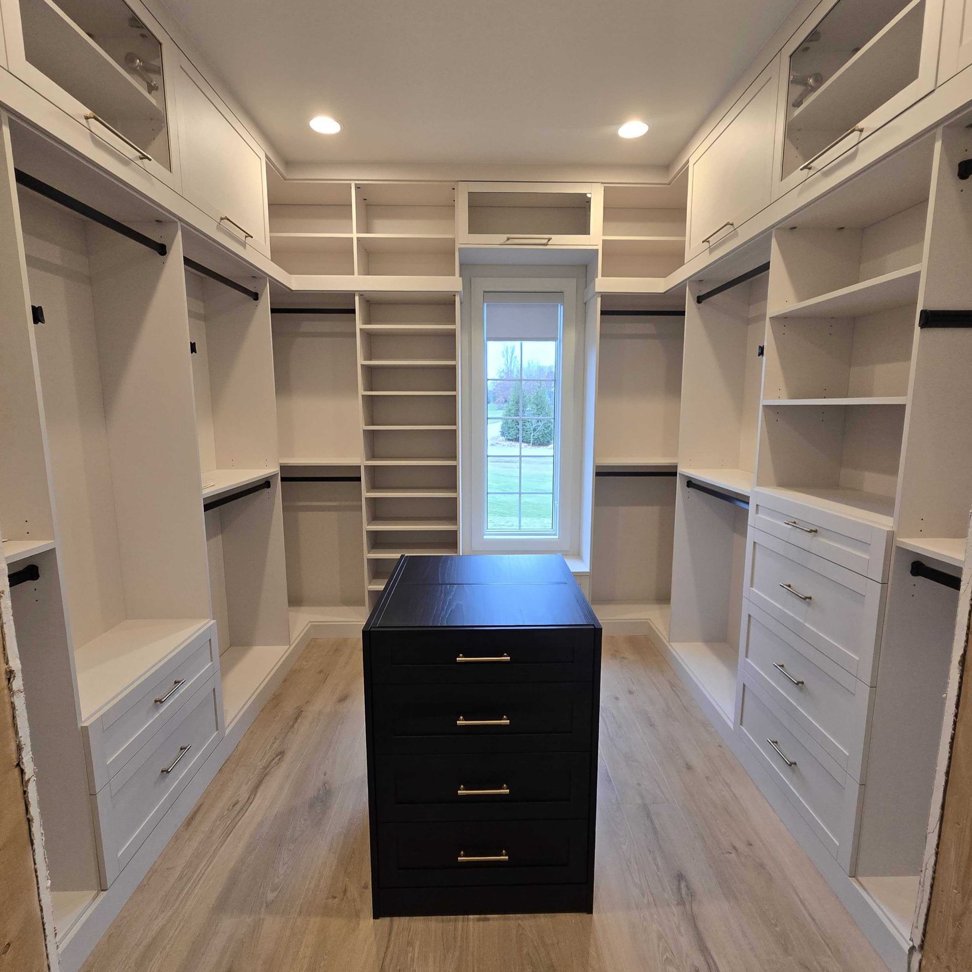 Custom Walk in Closet with doors and drawers and an island
