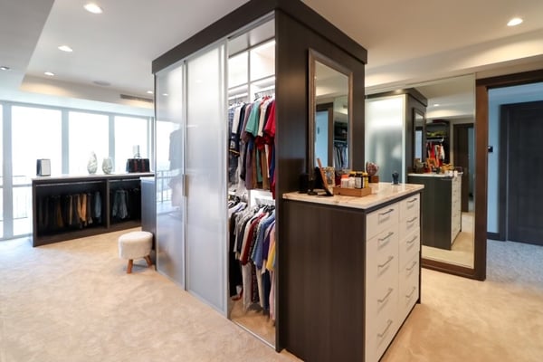 A walk-in closet in cappuccino with sleek white slab-fronts.