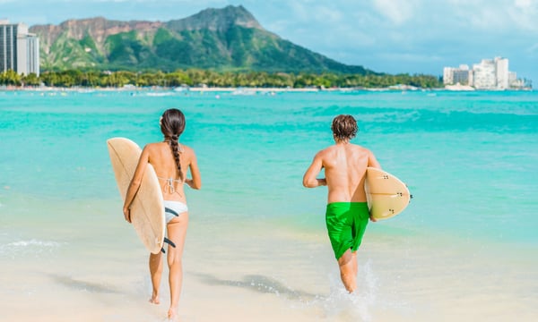 ビーチでサーフィンをするカップル