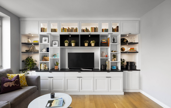 white & black modern entertainment center with cubby shelving and LED puck lighting