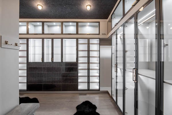 Luxury walk-in closet with slate aluminum and glass doors throughout.