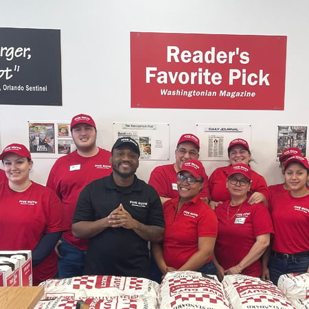 Employees pose for a photograph inside the restaurant ahead of the reopening of the Five Guys at 197 Boston Post Road West in Marlborough, Massachusetts.