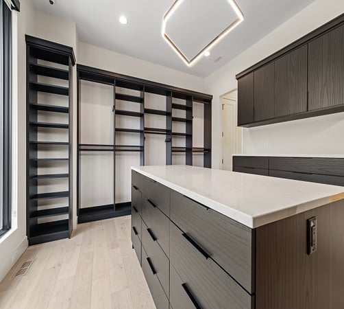 Custom walk in closet design with closet systems, island storage, and closet organization