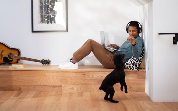 Man using WiFi at home in his nook, and interacting with his dog