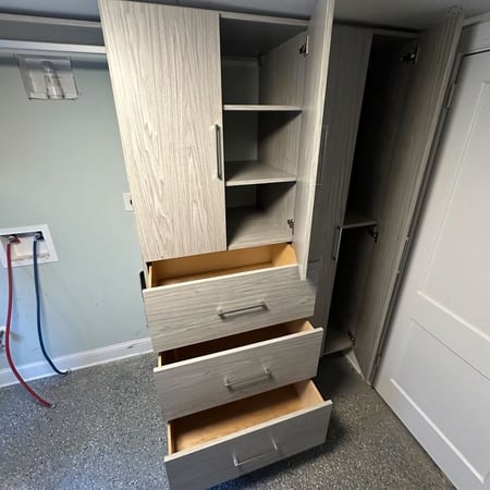 Greensboro - Custom closets - tall wood-finish cabinet with open doors and drawers extended to show adjustable shelving and storage capacity