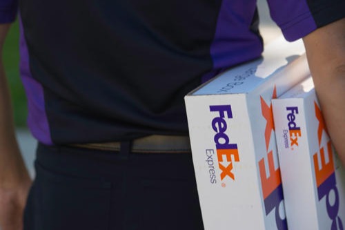 FedEx Express employee holding packages