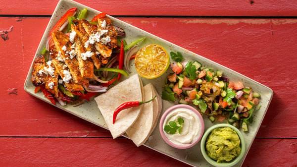 A fajita with fresh tortillas, veggies, pico de gallo, sour crema, and guacamole.