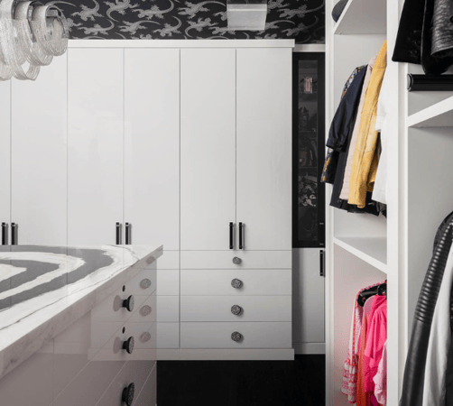 white full-room walk-in closet with black hardware, black and white closet, closed cabinetry doors, open hanging space, drawers, center island with black & white marble countertop Dutchess NY