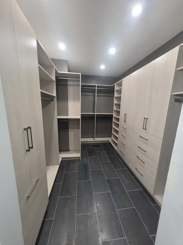 Custom Walk-in closet with black tile floor and light beige color boards