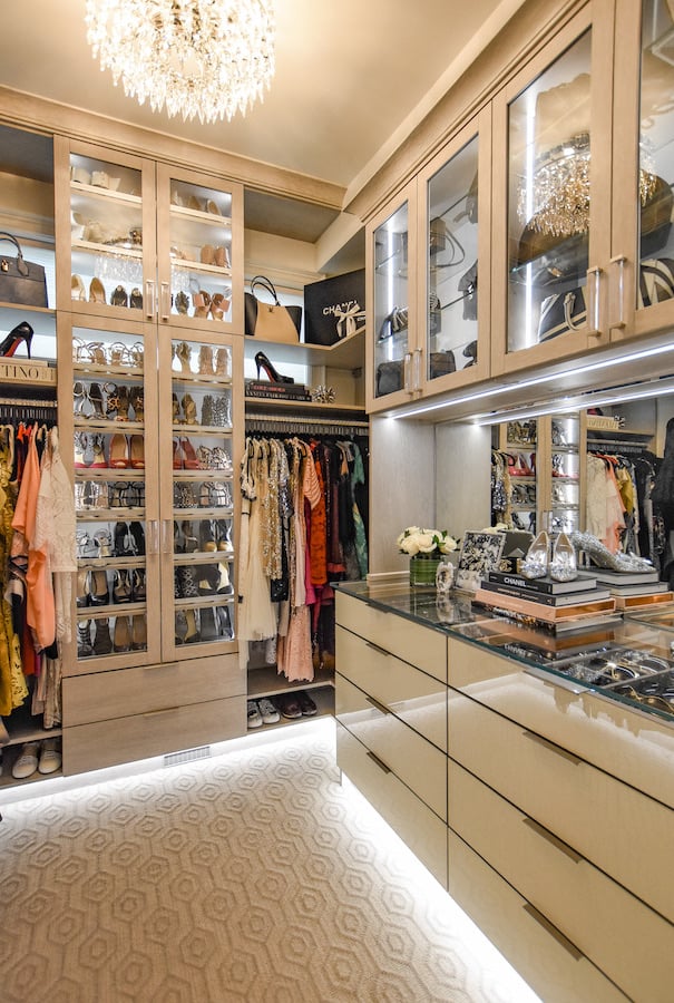 Walk-in closet with cabinet lighting, glass countertop, doors by California Closets Greater Detroit, MI.
