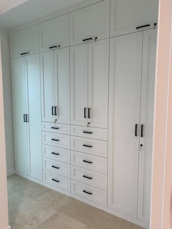 White wardrobe closet with dark hardware