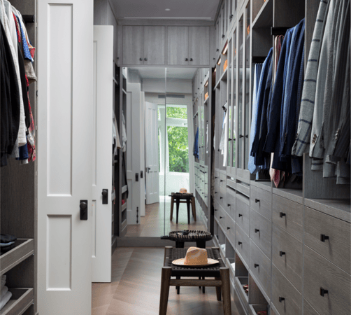 Light Gray full-room walk-in closet with drawers, custom jewelry drawers, LED lighting, glass see through doors over hanging clothes, and modern black hardware Westchester NY mirrored doors