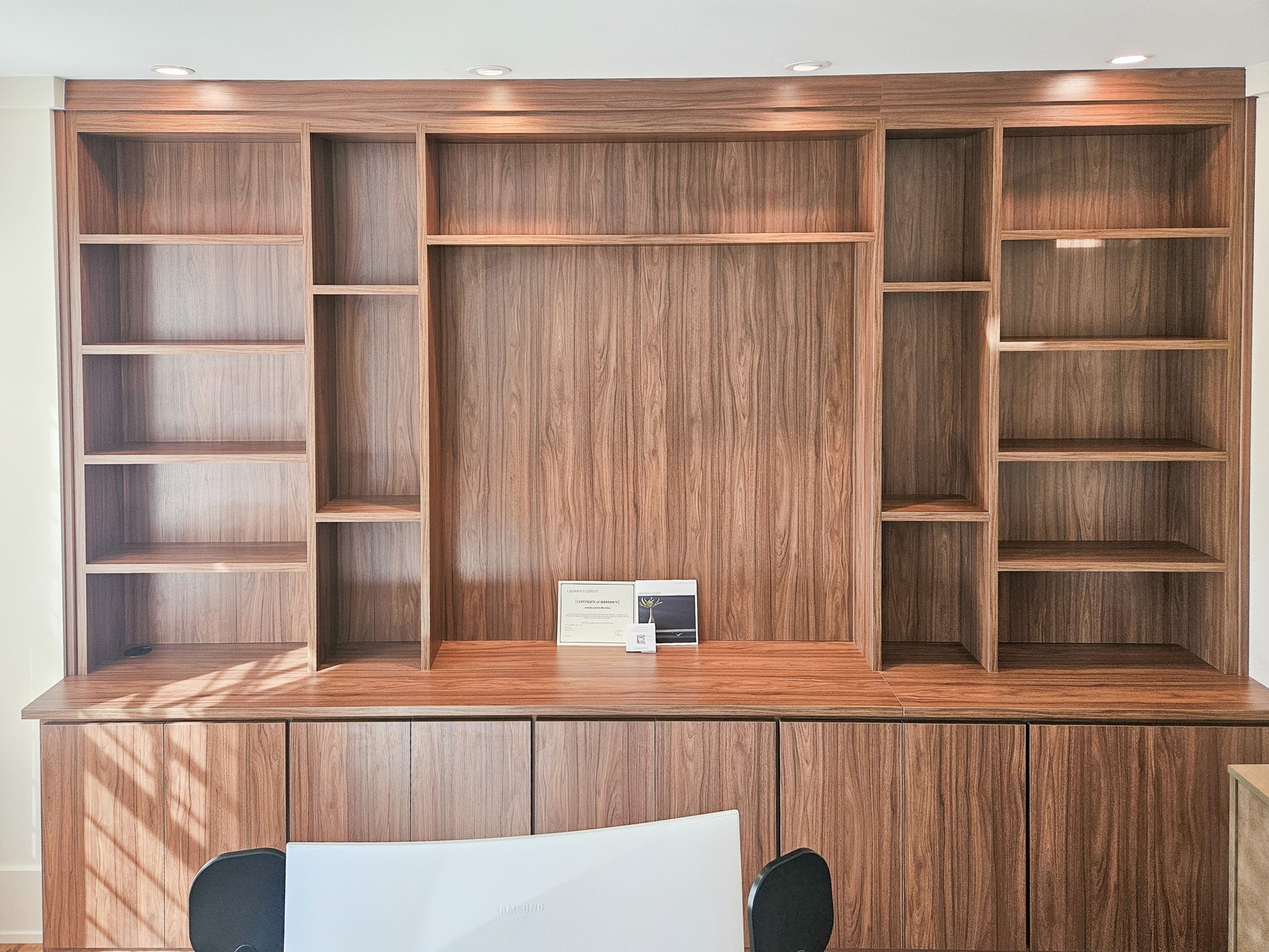 Home office with floor to ceiling storage and lighting.