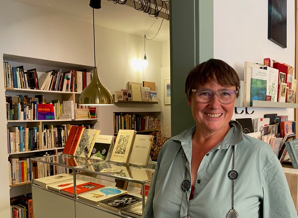 Odile, la propriétaire est assortie au décor de sa librairie. A sa gauche, sur le meuble USM, nous exposons nos livres les plus beaux ou les plus insolites !