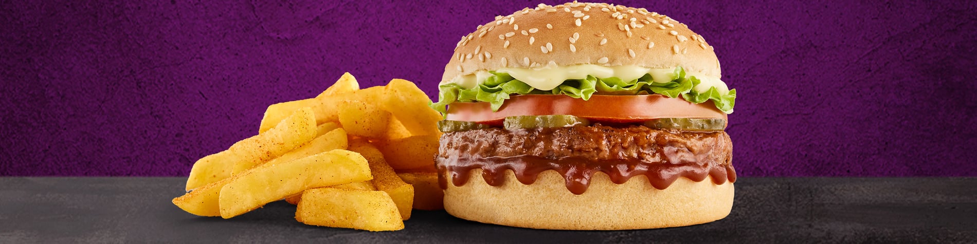 The NEW Mo’MjojoTM Burger Meal from Steers® Sam Ntuli Katlehong. 2 Flame-Grilled pure beef patties, pineapple, macon, tomato, lettuce, and small Famous Hand-Cut Chips, on a purple background.