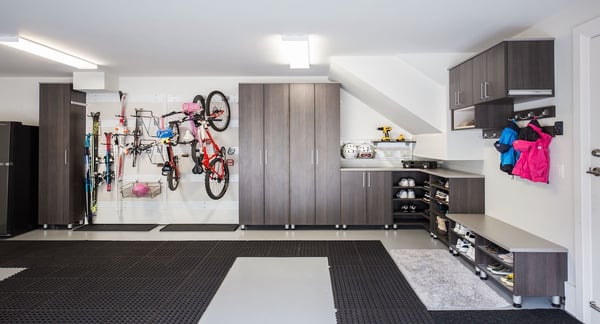 Garage storage with cabinets with dark wood cabinets and fusion track wall