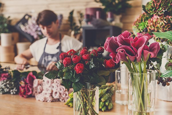 Florist preparing a floral tribute from a variety of funeral flowers