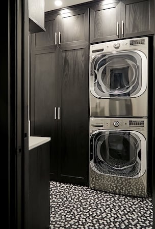 Laundry room storage with cabinets, folding counter in dark wood by California Closets Chicago.
