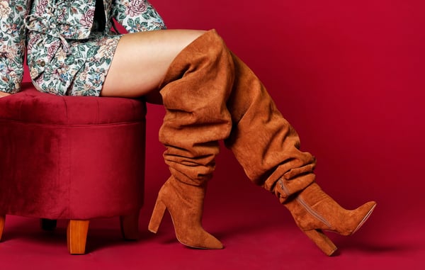 Women is wearing tall brown scrunch boots.