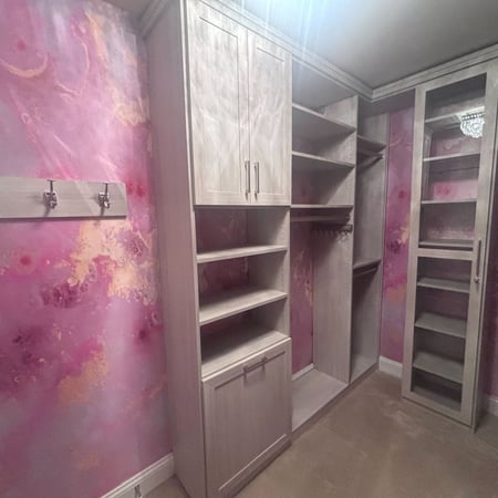 Richmond - Custom closets - closet with soft wood cabinetry set against pink and gold accent walls, featuring shelving, drawers, and hanging space