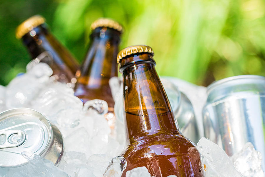 bottled and canned beer in a cooler of ice