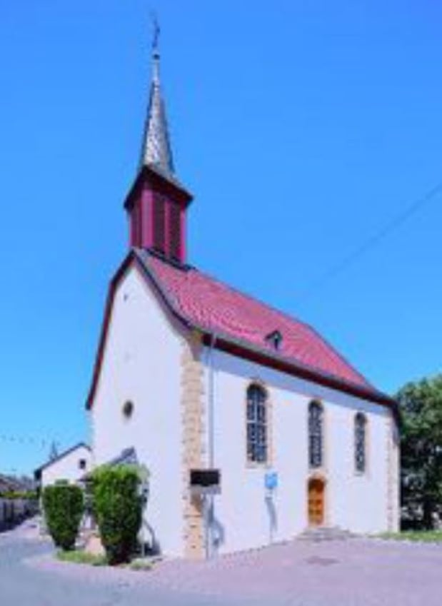 Außenansicht der Kirche in Bubenheim. Das Gebäude ist in weiß gehalten und das Dach ist rot.