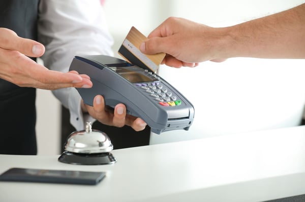 受付でホテルの部屋代を払っている男性