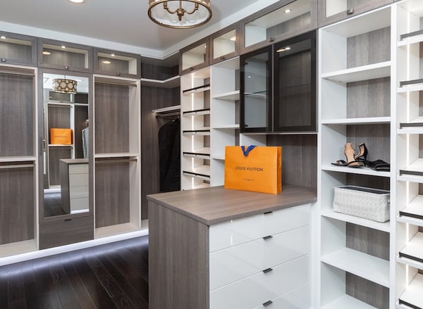 Walk-in closet with custom cabinets, shelves, drawers, and shoe storage in light wood by California Closets Greater Detroit, Michigan.