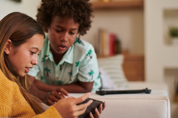 boy and girl playing on device