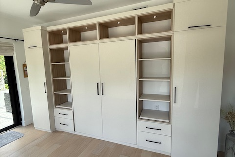 Custom wall bed with surrounding wardrobe units in Linen with Cassini Beach accents, featuring black hardware, integrated lighting, and full overlay design for a seamless modern look.