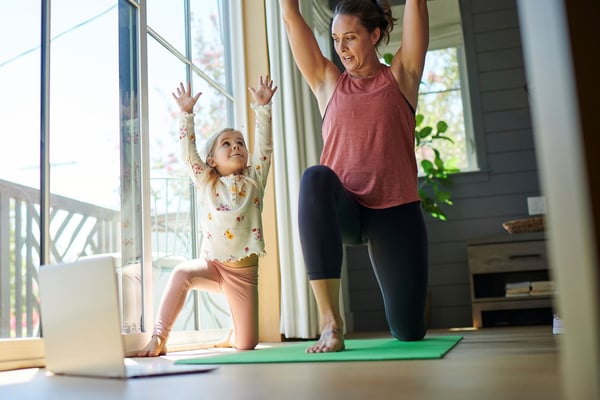 Madre e hija que hacen yoga en su hogar