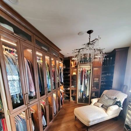 Brown walk in closet with lights for closet and glass doors by California Closets Baldwin County & Mobile, Alabama