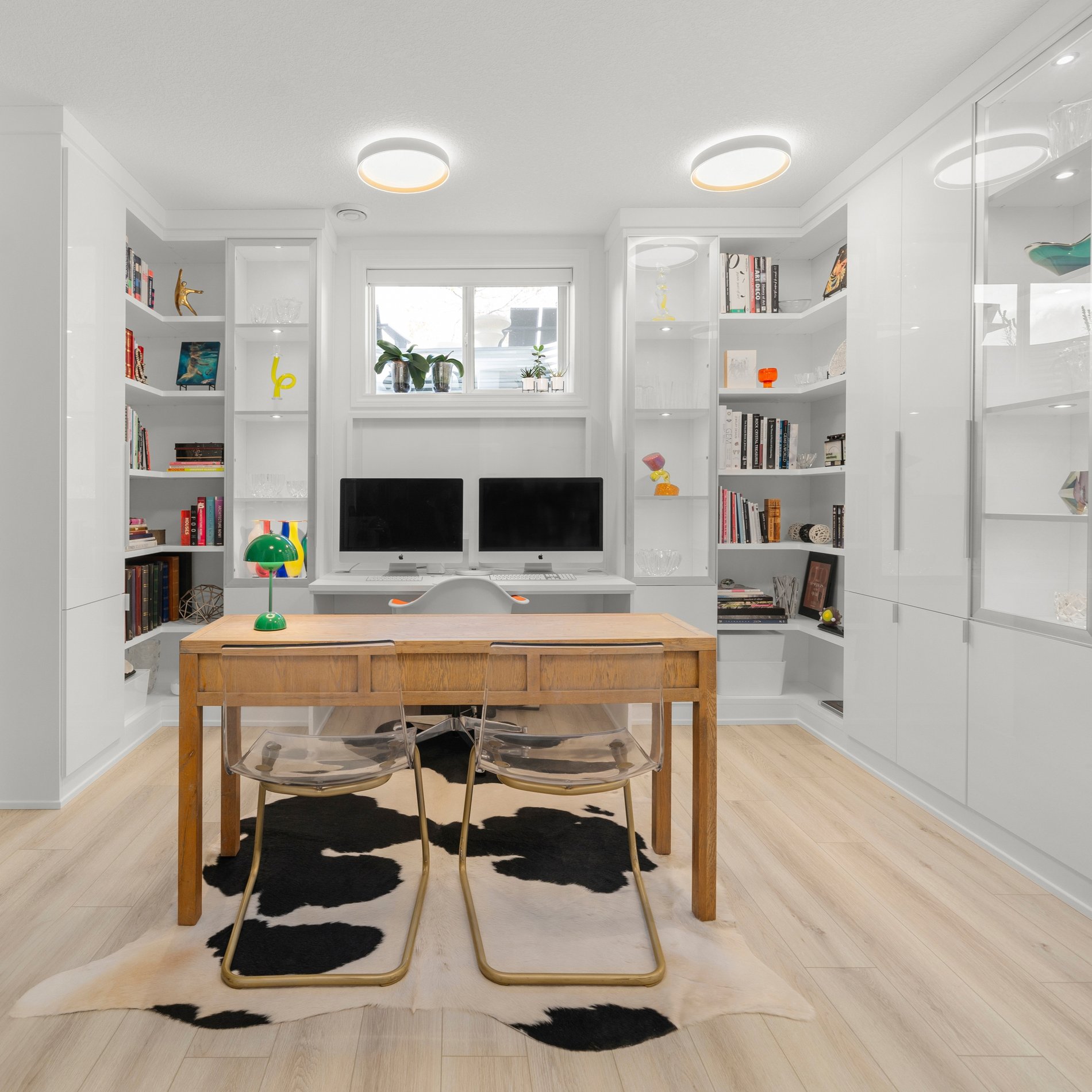 Floor to ceiling storage in this home office. Designed in a white finish with white high gloss door fronts. Open shelving provide the perfect space for displaying books and collectible