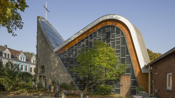 Ein modernes Kirchengebäude mit mit einem markanten gerundetem Dach.