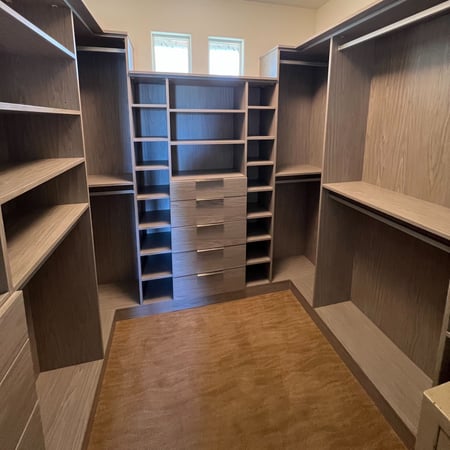 Tan walk-in closet with pull out drawers