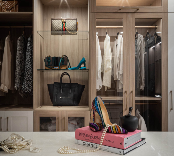 Img 4 California Closets Westchester County New York Two Toned White and Beige Large Walk-in Luxury Closet with Glass Shelving, Glass Doors, Lighting, and a Custom Center Island with Custom Jewelry Drawers