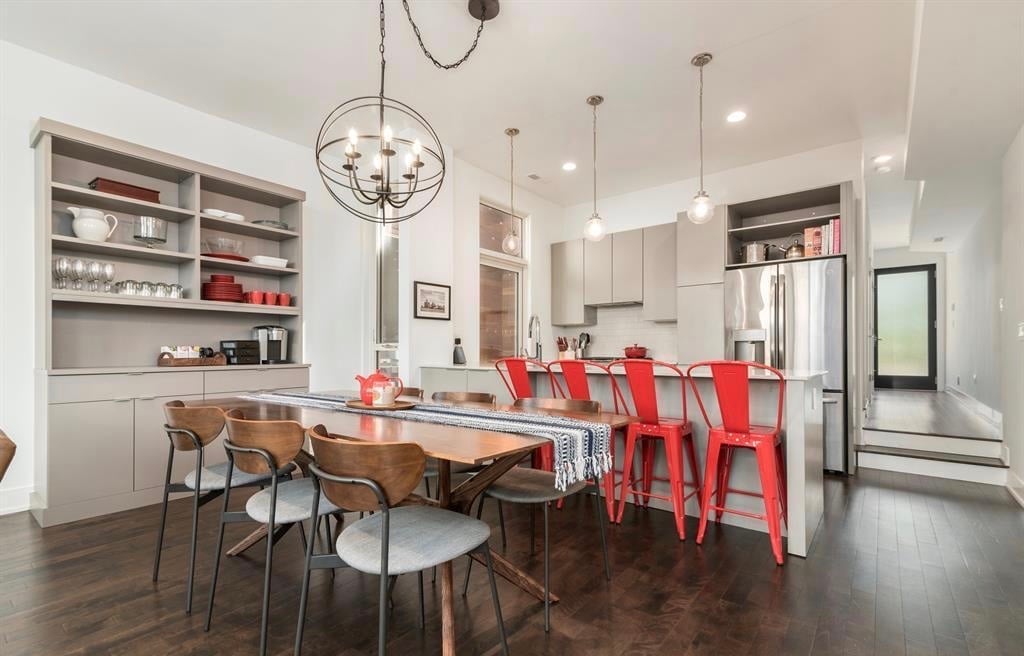 Dining room hutch with modern chairs and red accent chairs.