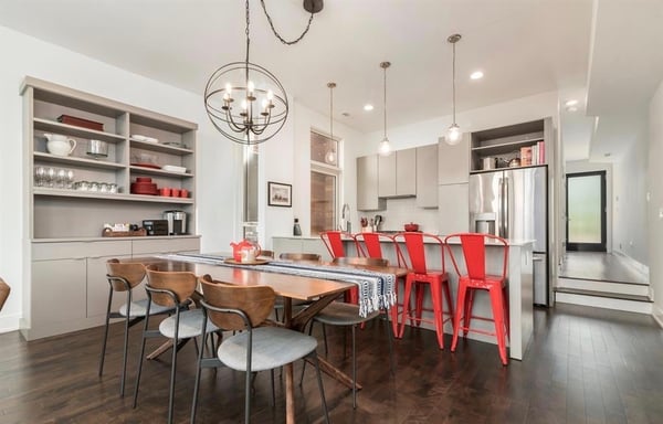Dining room hutch with modern chairs and red accent chairs.