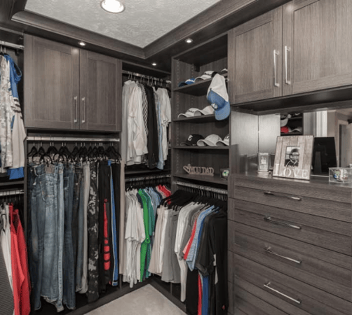 Bedroom closet with hanging space, shelving, drawers, and cabinets.