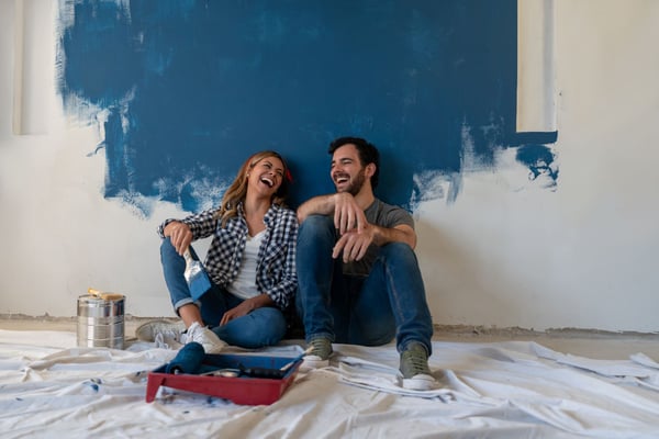 Young couple laughing while renovating new home.